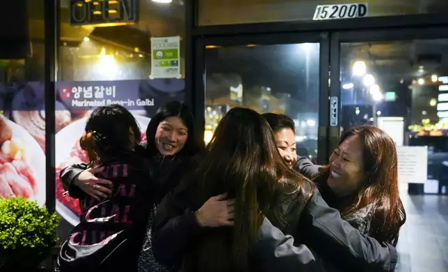 Korean adoptee Rebecca Kimmel, right, hugs Michelle Leco, center, and Jenny Kelly, left, after leaving dinner at Yetgol Old Village Korean BBQ with fellow adoptees, Sunday, Jan. 28, 2024, in Seattle. The Korean adoptee diaspora is thought to be the largest in the world, with thousands returning to South Korea in recent years to look for their birth families. (AP Photo/Lindsey Wasson)