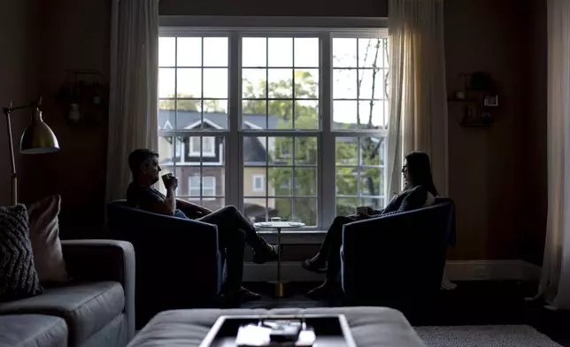 Dee Iraca, right, who was adopted as a baby out of South Korea to a family in the United States, sits with her husband, Sean, Saturday, April 6, 2024, at their home in Davidson, N.C. (AP Photo/David Goldman)