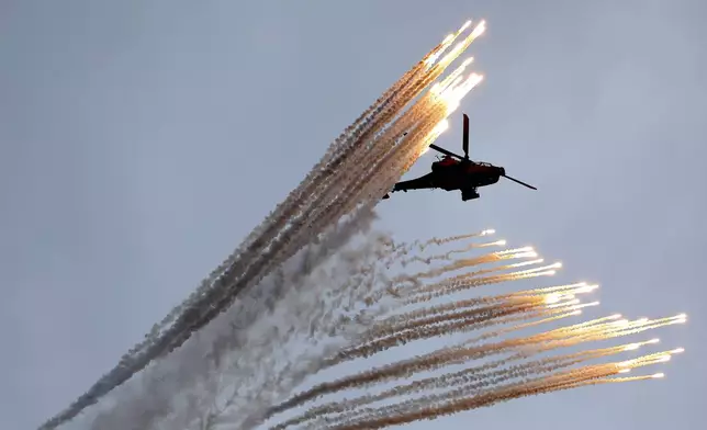 A South Korean army Apache helicopter fires flares during a celebration to mark 76th anniversary of Korea Armed Forces Day, in Seongnam, South Korea, Tuesday, Oct.1, 2024. (Kim Hong-Ji/Pool Photo via AP)