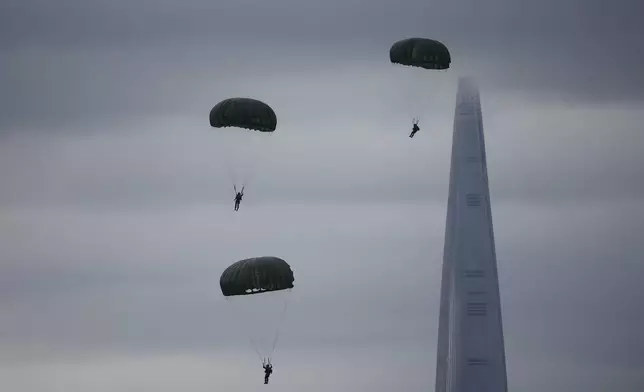 Members of the Special Warfare Command parachute as 123-storey skyscraper Lotte World Tower is seen in the background during a celebration to mark 76th anniversary of Korea Armed Forces Day, in Seongnam, South Korea, Tuesday, Oct.1, 2024. (Kim Hong-Ji/Pool Photo via AP)