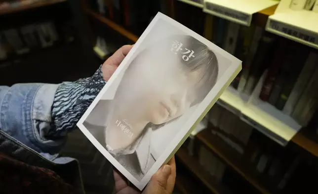 A woman holds a South Korean author Han Kang's book at a bookstore in Goyang, South Korea, Thursday, Oct. 10, 2024. (AP Photo/Lee Jin-man)