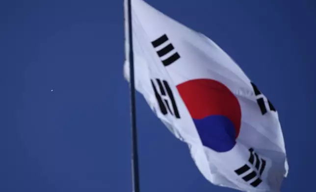 A South Korean national flag flutters in the wind at the Unification Observation Post as North Korean balloons, left, fly in Paju, South Korea, near the border with North Korea, Friday, Oct. 4, 2024. (AP Photo/Lee Jin-man)