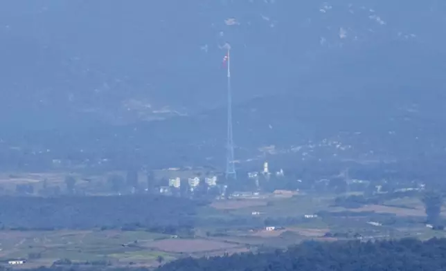 A North Korean flag flutters in the wind atop a 160-meter (525-foot) tower in the North's Kijong-dong village near the truce village of Panmunjom, seen from Paju, South Korea, near the border with North Korea, Friday, Oct. 4, 2024. (AP Photo/Lee Jin-man)