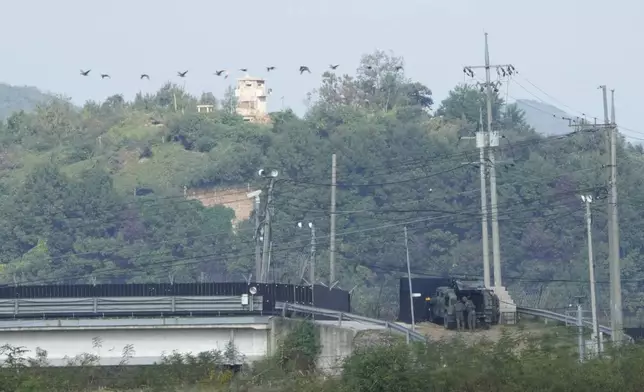 A North Korean military guard post, top, and South Korean army soldiers, bottom, are seen from Paju, South Korea, near the border with North Korea, Thursday, Oct. 10, 2024. (AP Photo/Ahn Young-joon)