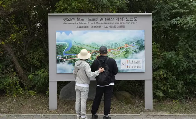 South Korean visitors look at a map which shows a border area of two Koreas with a railroad line between Munsan city in south and Kaesong in north, at the Imjingak Pavilion in Paju, South Korea, near the border with North Korea, Monday, Oct. 14, 2024. (AP Photo/Ahn Young-joon)