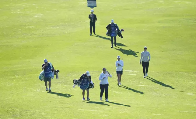 Ashleigh Buhai of South Africa, center, Jenny Shin of South Korea, second from right, and Hannah Green, of Australia, right, walks on the 12th fairway during the second round of the LPGA Ladies Championship golf tournament at the Seowon Valley Country Club in Paju, South Korea, Saturday, Oct. 19, 2024. (AP Photo/Lee Jin-man)