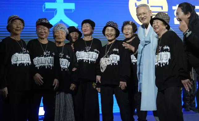 Members of Suni and the Seven Princesses stand for a photograph with South Korea's Minister of Culture, Sports and Tourism Yu In Chon, after performing at the "Hangeul Week" at Gwanghwamun square in Seoul, South Korea, Friday, Oct. 4, 2024. (AP Photo/Lee Jin-man)