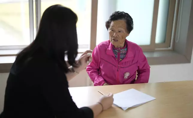 Kang Hye-eun makes corrections to some Korean words written by her grandmother Park Jeom-sun, 82, leader of Sunni and the Seven Princesses, at a senior community center in Chilgok, South Korea, Thursday, Oct. 3, 2024. (AP Photo/Lee Jin-man)