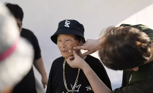 Park Jeom-sun, 82, leader of Suni and the Seven Princesses, prepares for the opening of an event celebrating the heritage of the Korean alphabet, called "Hangeul," at Gwanghwamun square in Seoul, South Korea, Friday, Oct. 4, 2024. (AP Photo/Lee Jin-man)