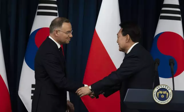 South Korean President Yoon Suk Yeol, right, and Poland's President Andrzej Duda, left, shake hands after a joint press conference at the Presidential Office in Seoul, South Korea, Thursday, Oct. 24, 2024. (Jeon Heon-Kyun/Pool Photo via AP)