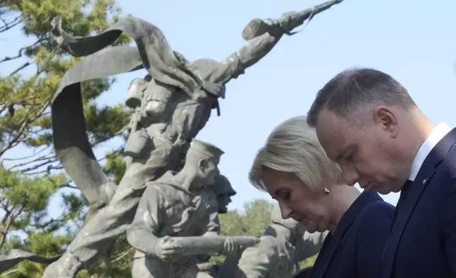 Polish President Andrzej Duda, right, and his wife Agata Kornhauser-Duda pay a silent tribute at the National Cemetery in Seoul, South Korea, Thursday, Oct. 24, 2024. (AP Photo/Ahn Young-joon)