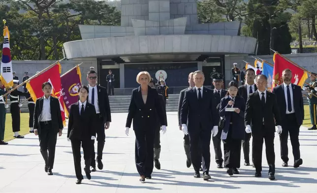 Polish President Andrzej Duda, center right, and his wife Agata Kornhauser-Duda, center left, visit the National Cemetery in Seoul, South Korea, Thursday, Oct. 24, 2024. (AP Photo/Ahn Young-joon)