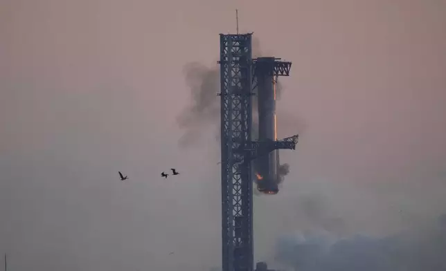 SpaceX's mega rocket booster returns to the launch pad to be captured during a test flight Sunday, Oct. 13, 2024, in Boca Chica,, Texas. (AP Photo/Eric Gay)