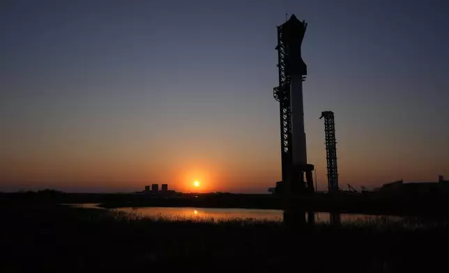 The sun sets behind SpaceX's mega rocket Starship, Saturday, Oct. 12, 2024, in Boca Chica, Texas. (AP Photo/Eric Gay)