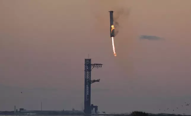 SpaceX's mega rocket booster returns to the launch pad to be captured during a test flight, Sunday, Oct. 13, 2024, in Boca Chica,, Texas. (AP Photo/Eric Gay)