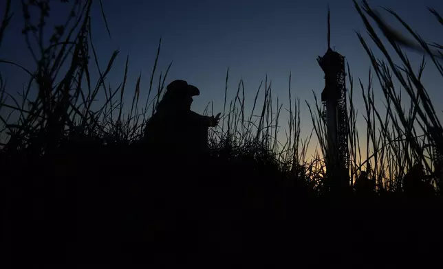 Noah Jansko watches as the sun sets behind SpaceX's mega rocket Starship, Saturday, Oct. 12, 2024, in Boca Chica, Texas. (AP Photo/Eric Gay)