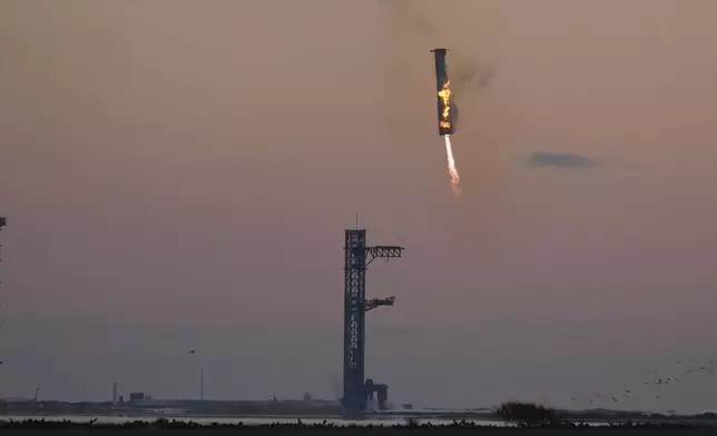 SpaceX's mega rocket booster returns to the launch pad to be captured during a test flight Sunday, Oct. 13, 2024, in Boca Chica,, Texas. (AP Photo/Eric Gay)