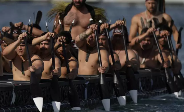 Maori rowers escort Emirates Team New Zealand boat in a traditional waka, or a canoe, ahead of the Louis Vuitton 37th America's Cup Day 6 race 9 in Barcelona, Spain, Saturday, Oct.19, 2024. (AP Photo/Bernat Armangue)