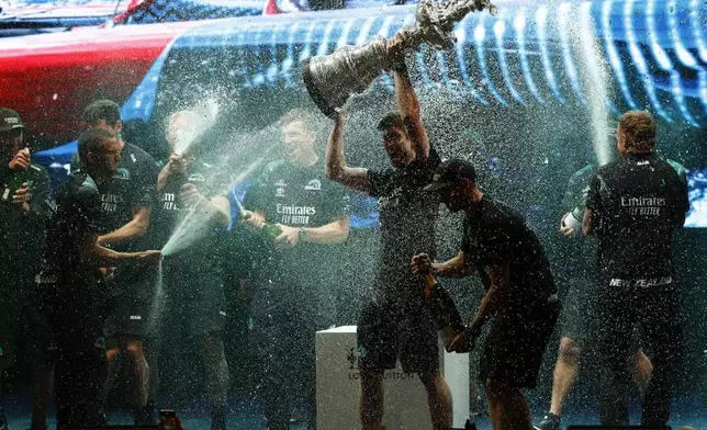 Emirates Team New Zealand skipper Peter Burling lifts the trophy after winning the Louis Vuitton 37th America's Cup in Barcelona, Spain, Saturday, Oct.19, 2024. (AP Photo/Joan Monfort)