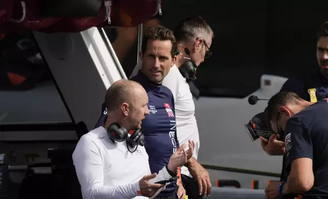 Ineos Britannia skipper Ben Ainslie, center, talks to the crew during the Louis Vuitton 37th America's Cup Day 2 race in Barcelona, Spain, Sunday, Oct. 13, 2024. (AP Photo/Bernat Armangue)