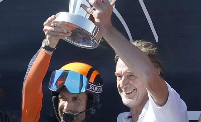 INEOS Britannia Chairman Jim Ratcliffe, right, and team skipper Ben Ainslie crew celebrate their team victory against the Luna Rosa Prada Pirelli's sailing team during the Louis Vuitton Cup Final Day 7 at the Barcelona's coast, Spain, Friday, Oct. 4, 2024. (AP Photo/Joan Monfort)