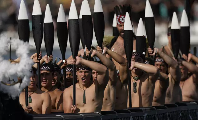 Maori rowers escort Emirates Team New Zealand boat in a traditional waka, or a canoe, ahead of the Louis Vuitton 37th America's Cup Day 6 race 9 in Barcelona, Spain, Saturday, Oct.19, 2024. (AP Photo/Bernat Armangue)