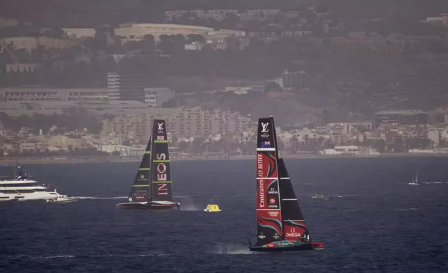 Ineos Britannia, left, and Emirates Team New Zealand race during the Louis Vuitton 37th America's Cup Day 4 race 5 in Barcelona, Spain, Wednesday, Oct. 16, 2024. (AP Photo/Emilio Morenatti)