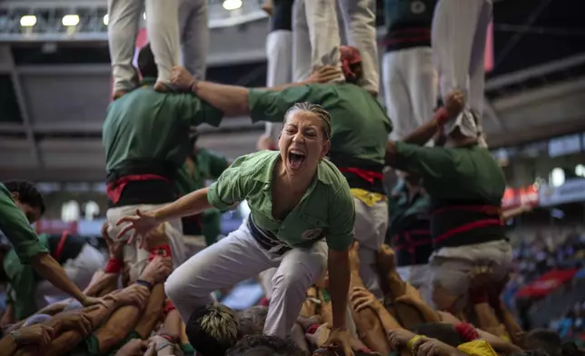 Members of "Castellers de Sant Cugat" react after successfully completing their "Castell", during the 29th Human Tower Competition in Tarragona, Spain, Saturday, Oct. 5, 2024. (AP Photo/Emilio Morenatti)