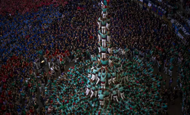 Member of "Castellers de Vilafranca" form a "Castell" or human tower, during the 29th Human Tower Competition in Tarragona, Spain, Sunday, Oct. 6, 2024. (AP Photo/Emilio Morenatti)