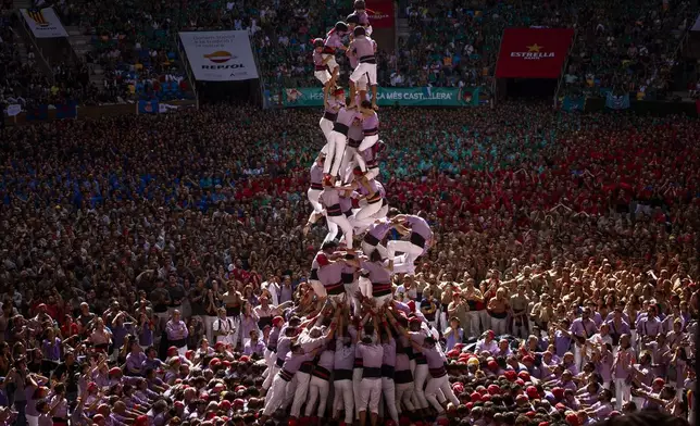 Members of "Colla Jove de Tarragona" fall before completing a "Castell" or human tower, during the 29th Human Tower Competition in Tarragona, Spain, Sunday, Oct. 6, 2024. (AP Photo/Emilio Morenatti)