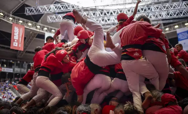 Members of "Colla Joves Xiquets de Valls" fall as they try to form a "Castell" or human tower, during the 29th Human Tower Competition in Tarragona, Spain, Sunday, Oct. 6, 2024. (AP Photo/Emilio Morenatti)