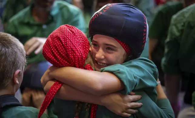 Valeria, 11, reacts after climbing to the top of a "castell" or human tower during the 29th Human Tower Competition in Tarragona, Spain, Saturday, Oct. 5, 2024. (AP Photo/Emilio Morenatti)