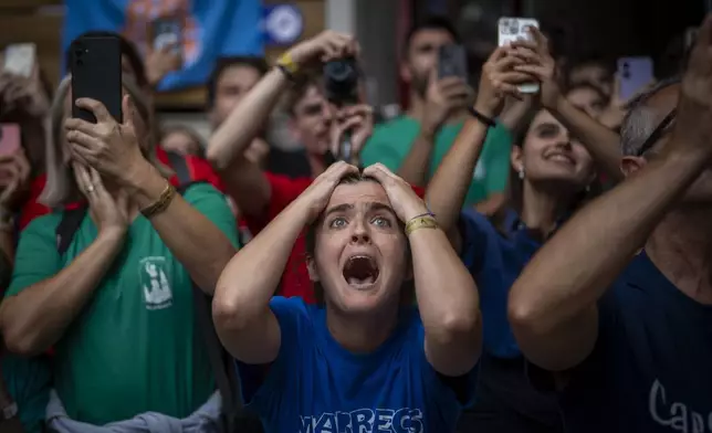 Assistants react as members of "Castellers de Vilafranca" try to form a "Castell" or human tower, during the 29th Human Tower Competition in Tarragona, Spain, Sunday, Oct. 6, 2024. (AP Photo/Emilio Morenatti)