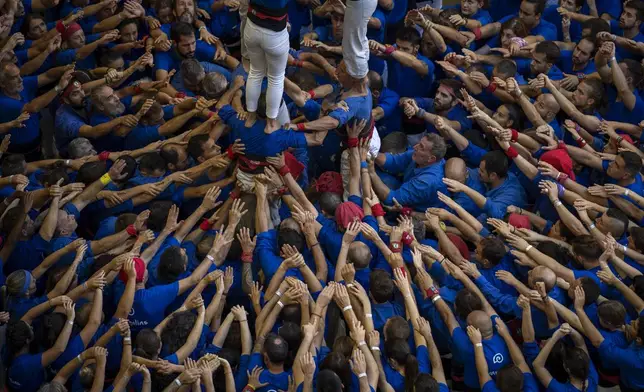 Members of "Castellers de la Vila de Gracia" form a "Castell" or human tower, during the 29th Human Tower Competition in Tarragona, Spain, Saturday, Oct. 5, 2024. (AP Photo/Emilio Morenatti)