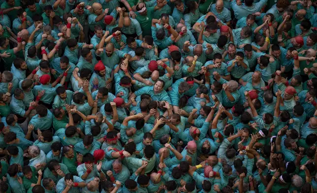 Members of "Castellers de Vilafranca" celebrate after completing a "Castell" or human tower, during the 29th Human Tower Competition in Tarragona, Spain, Sunday, Oct. 6, 2024. (AP Photo/Emilio Morenatti)