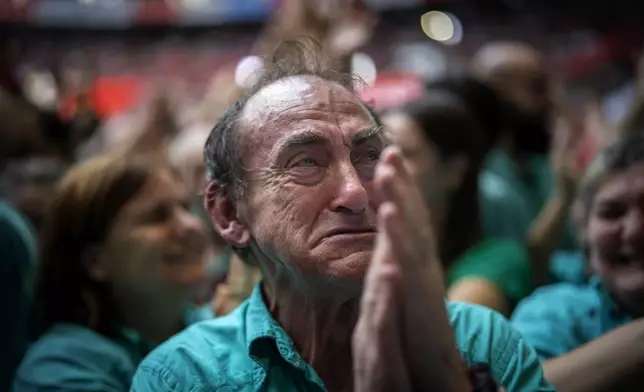 Juan Antonio Rodriguez, 72, reacts after performing next to members of "Castellers de Vilafranca" completing a "Castell" or human tower, during the 29th Human Tower Competition in Tarragona, Spain, Sunday, Oct. 6, 2024. (AP Photo/Emilio Morenatti)