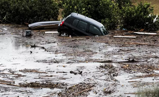 Cars are swept away by the water, after floods preceded by heavy rains caused the river to overflow its banks in the town of Alora, Malaga, Tuesday, Oct. 29, 2024. (AP Photo/Gregorio Marrero)