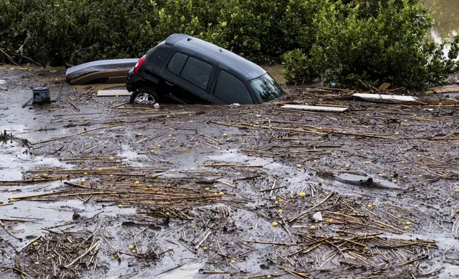 Cars are being swept away by the water, after floods preceded by heavy rains caused the river to overflow its banks in the town of Alora, Malaga, Spain, Tuesday, Oct. 29, 2024. (AP Photo/Gregorio Marrero)