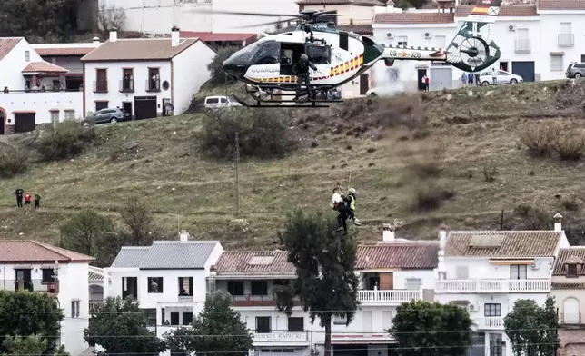 Emergency teams rescue a person who was stranded by the water in a Guardia Civil helicopter, after the floods preceded by heavy rains that caused the overflow of the river in the town of Alora, Malaga, Spain, Tuesday, Oct. 29, 2024. (AP Photo/Gregorio Marrero)