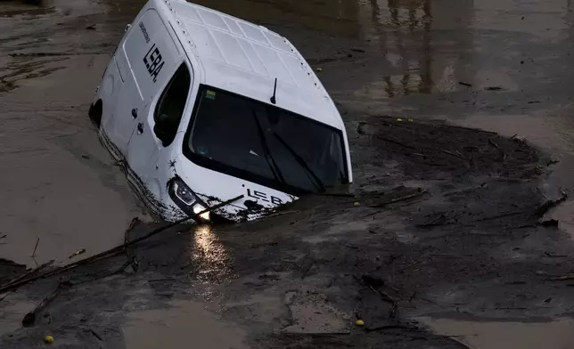 Cars are swept away by the water, after floods preceded by heavy rains caused the river to overflow its banks in the town of Alora, Malaga, Spain, Tuesday, Oct. 29, 2024. (AP Photo/Gregorio Marrero)