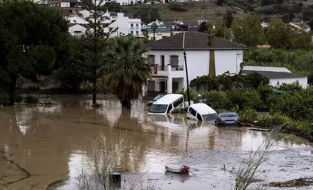 Cars are being swept away by the water, after floods preceded by heavy rains caused the river to overflow its banks in the town of Alora, Malaga, Tuesday, Oct. 29, 2024. (AP Photo/Gregorio Marrero)