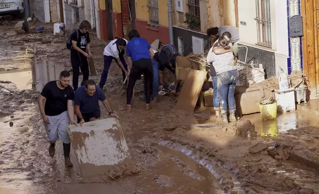 Residents clean their houses affected by floods in Valencia, Spain, Thursday, Oct. 31, 2024. (AP Photo/Alberto Saiz)