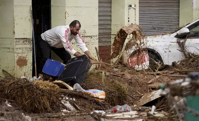 A man cleans his house affected by floods in Valencia, Spain, Wednesday, Oct. 30, 2024. (AP Photo/Alberto Saiz)