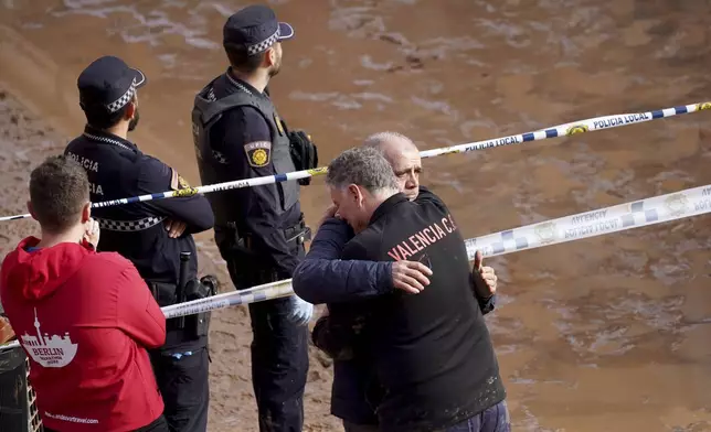 Residents react as they wait for news of their relatives trapped during the floods in Valencia, Spain, Thursday, Oct. 31, 2024. (AP Photo/Alberto Saiz)