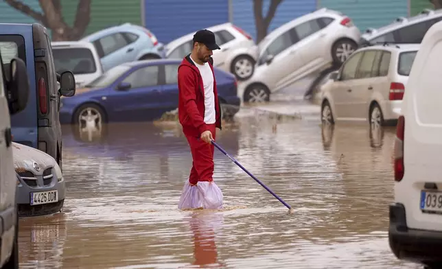 A man walks through flooded streets in Valencia, Spain, Wednesday, Oct. 30, 2024. (AP Photo/Alberto Saiz)