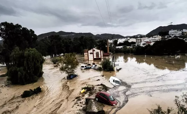 Cars are swept away by the water, after floods preceded by heavy rains caused the river to overflow its banks in the town of Alora, Malaga, Spain, Tuesday, Oct. 29, 2024. (AP Photo/Gregorio Marrero)