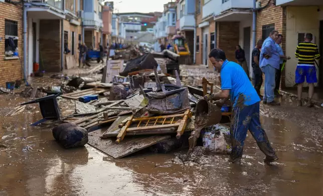 A man cleans his house affected by floods in Utiel, Spain, Wednesday, Oct. 30, 2024. (AP Photo/Manu Fernandez)