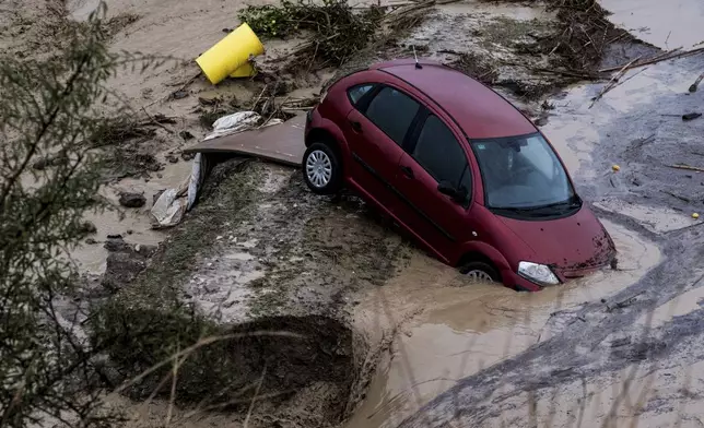 Cars are swept away by the water, after floods preceded by heavy rains caused the river to overflow its banks in the town of Alora, Malaga, Spain, Tuesday, Oct. 29, 2024. (AP Photo/Gregorio Marrero)