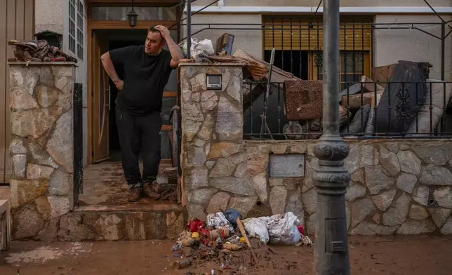 A man reacts in his house affected by floods in Utiel, Spain, Wednesday, Oct. 30, 2024. (AP Photo/Manu Fernandez)