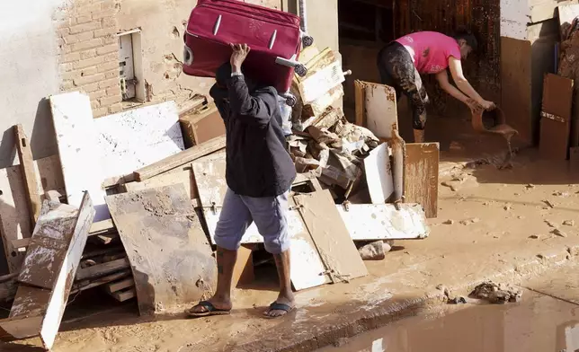 Residents clean their house affected by floods in Valencia, Spain, Thursday, Oct. 31, 2024. (AP Photo/Alberto Saiz)